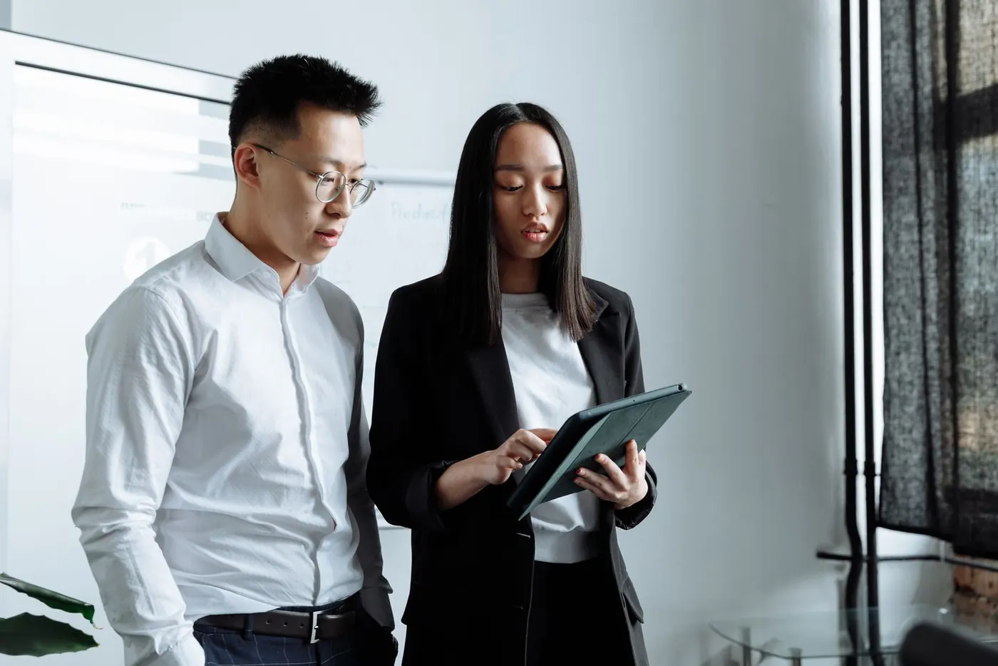 Two professionals reviewing a property on a tablet in a modern office